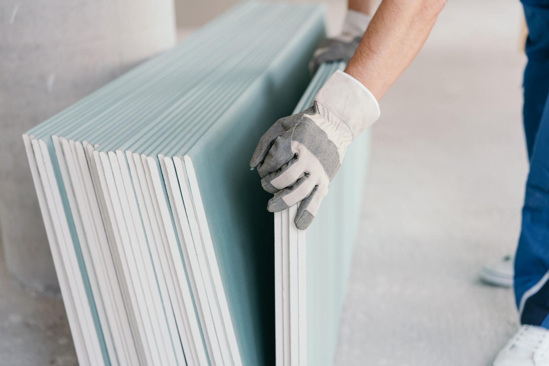 Builder taking a sheet of chip board cladding